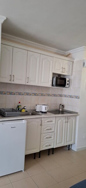 A kitchen with white cabinets, a microwave, a toaster, and a refrigerator. - Amara Apartment in a 3 pool holiday complex with bars and shops near to ocean (Golf del Sur)