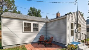 A single-story house with a patio area featuring a table and two chairs. - Walk to Park & Creek! Spearfish Couple’s Retreat (Spearfish)