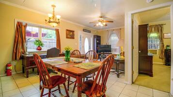 A dining room with a wooden table, chairs, and a ceiling fan.