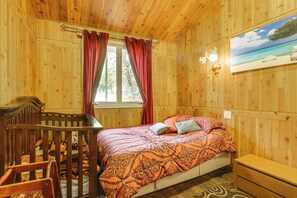 Ein Zimmer mit Holzboden, einem Bett, einem Schreibtisch und einem Stuhl.