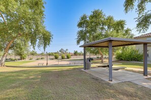 A covered outdoor area with a picnic table and a trash can. - Relax Poolside, Explore South Mtn! Extended Escape (Phoenix)
