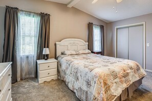 A bedroom with a bed, nightstand, dresser, and a closet.
