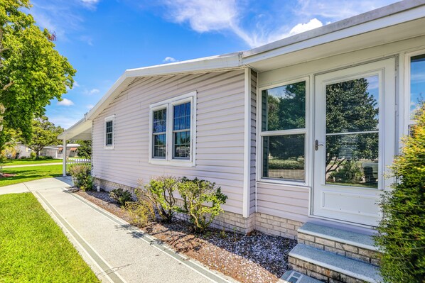 A single-story house with a front porch, a small front yard, and a clear sky.
