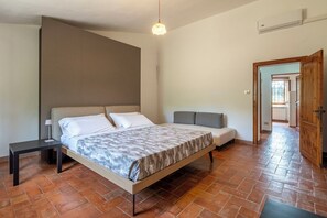 A bedroom with a bed, bedside table, and a bench.