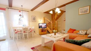 A cozy living room with a dining area, a staircase, and a television. - Babendörpstieg 20, Apt. 1 - 2-room vacation apartment in Nieblum, approx. 55 square meters, ground floor and upper floor (Nieblum)