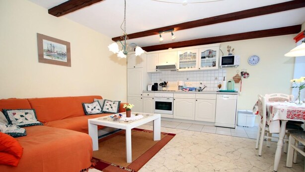 A living room with a sofa, coffee table, and a dining area with a table and chairs. - Babendörpstieg 20, Apt. 1 - 2-room vacation apartment in Nieblum, approx. 55 square meters, ground floor and upper floor (Nieblum)