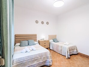A room with two beds, a bedside table with a lamp, and a wall with three decorative plates. - Casa Rural Villa Manantial by Interhome (Sevilla/La Puebla de Cazalla)
