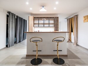 A modern kitchen with two bar stools, a built-in wine rack, and a pendant light. - Dominika by Interhome (Motovun)