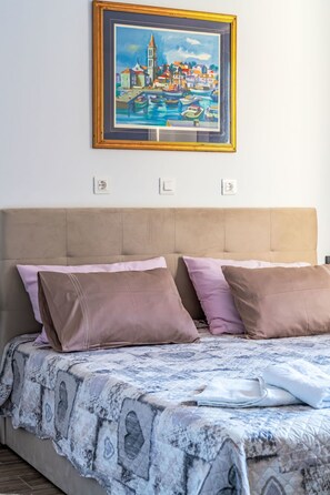 A bedroom with a bed, a headboard, and a framed painting on the wall. - Dominika by Interhome (Motovun)
