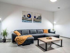A modern living room with a grey sofa, a coffee table, and two paintings on the wall. - Dominika by Interhome (Motovun)