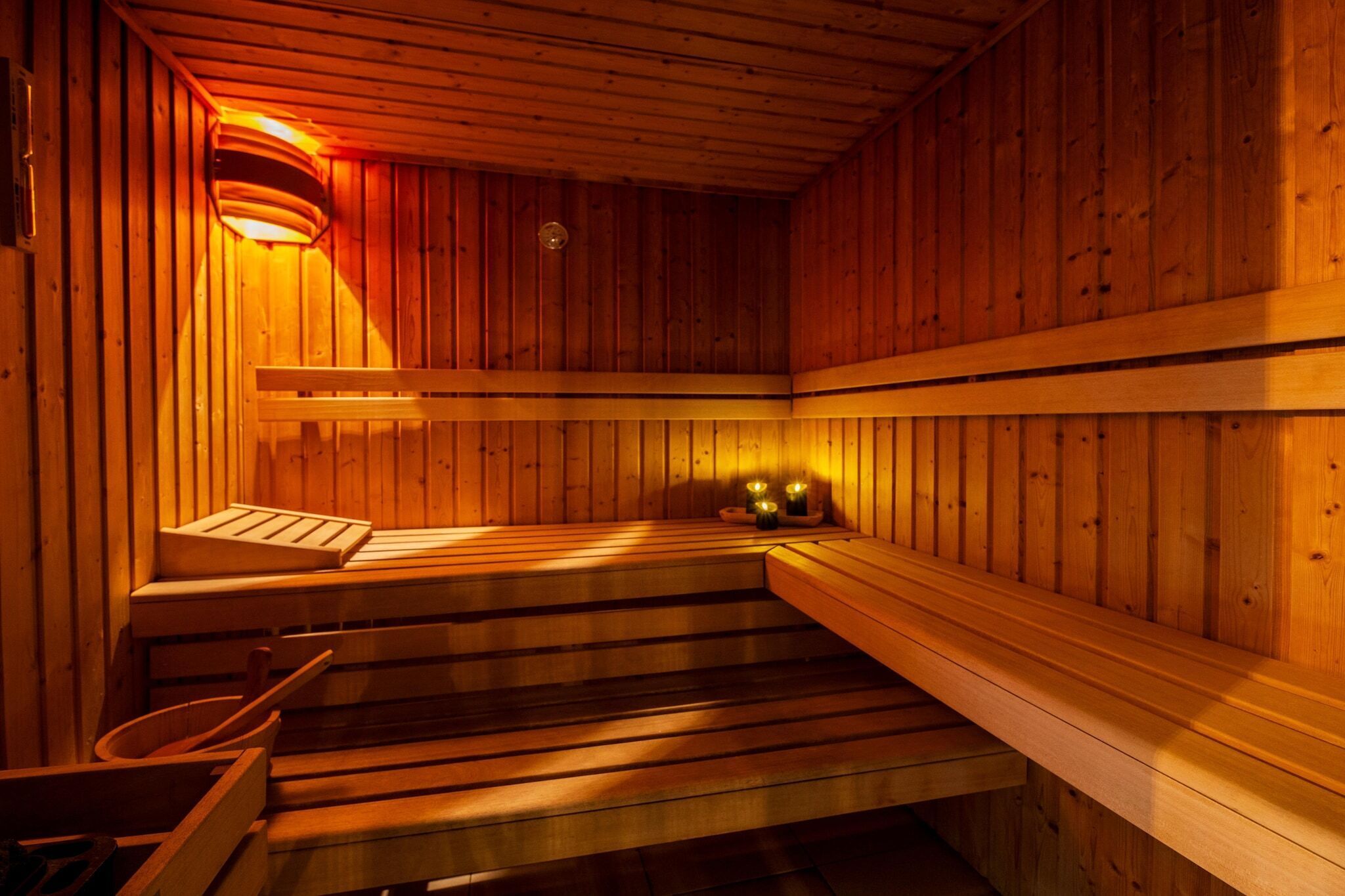 Een sauna met houten banken en een aflopende vloer.