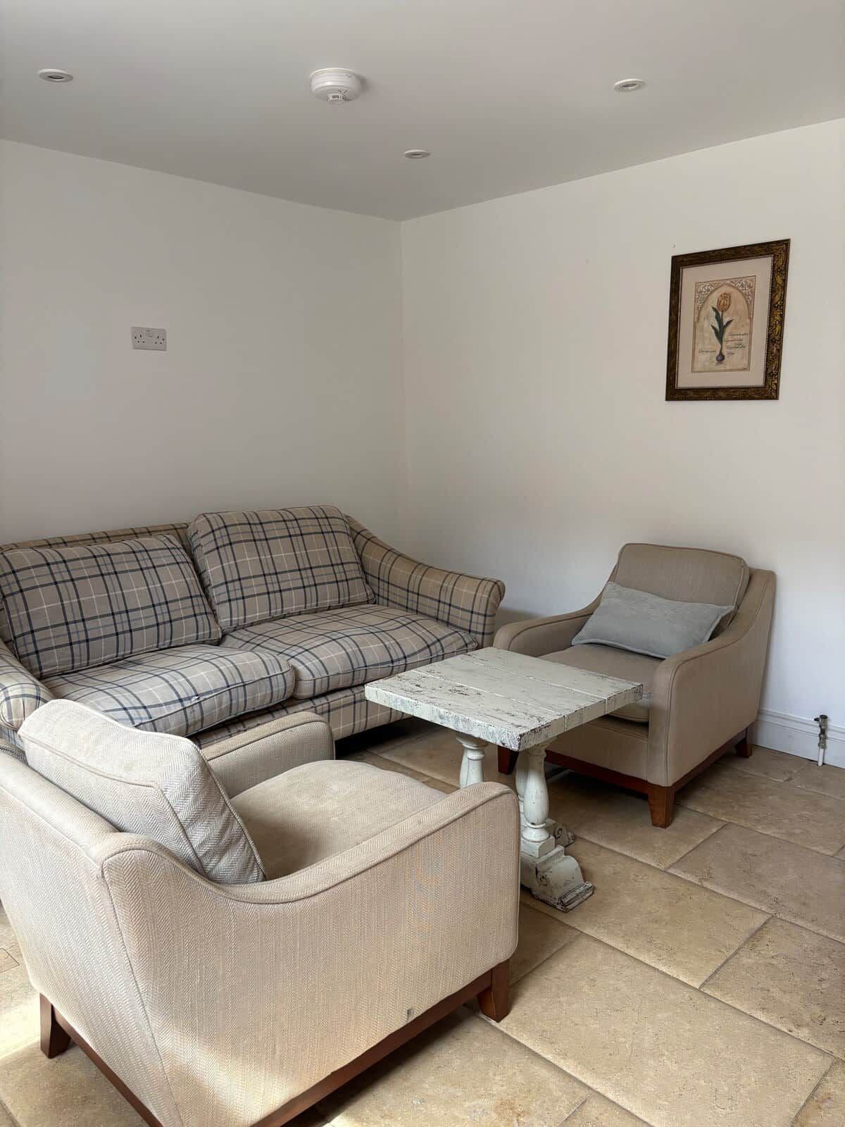 A living room with a sofa, armchair, and coffee table.