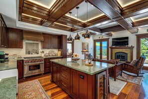 A spacious kitchen with a large island, wooden cabinets, and a built-in stove.