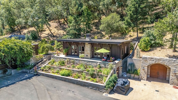 A modern house with a patio, stone walls, and a garden.
