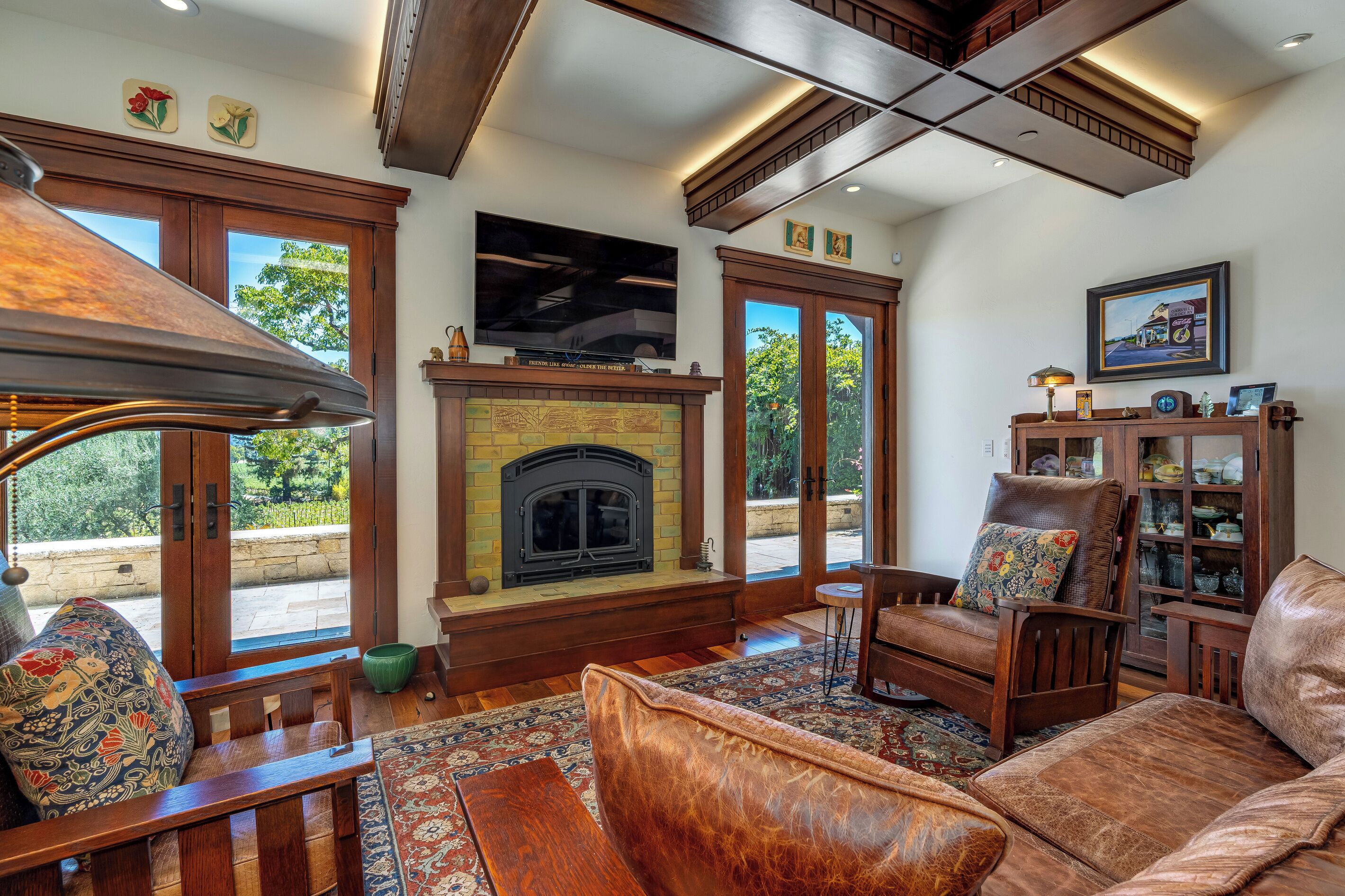 A living room with a fireplace, wooden furniture, and a television.