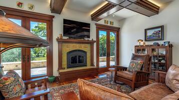 A living room with a fireplace, wooden furniture, and a television.