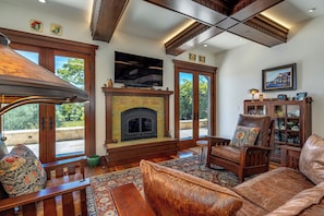 Una sala de estar con chimenea, muebles de madera y televisión.