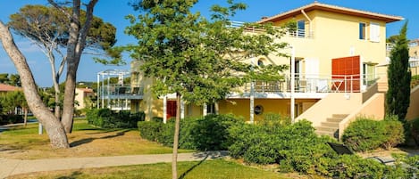 A two-story building with a balcony and a covered outdoor seating area.
