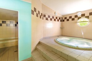 Ein Badezimmer mit Badewanne, gefliesten Wänden und einer Duschkabine.
