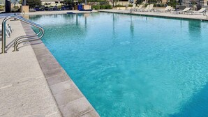 A clear swimming pool with a lifeguard chair and lounge chairs along the edge. - The Villa Suite @ Gilbert | Garage + Community Pool (Gilbert)