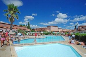 A swimming pool surrounded by a fence with people around it. - Apartment with loft in Ringkøbing (Saint-Cyprien)
