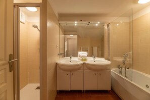 Ein Badezimmer mit zwei Waschbecken, einer Badewanne und einer Dusche.