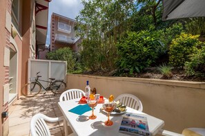 Eine Terrass mit Sitzgelegenheit für zwei Personen, einem Fahrrad und einer Broschüre für Lagrange Vacances.