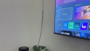 A flat-screen TV mounted on a wall displaying a streaming service interface.