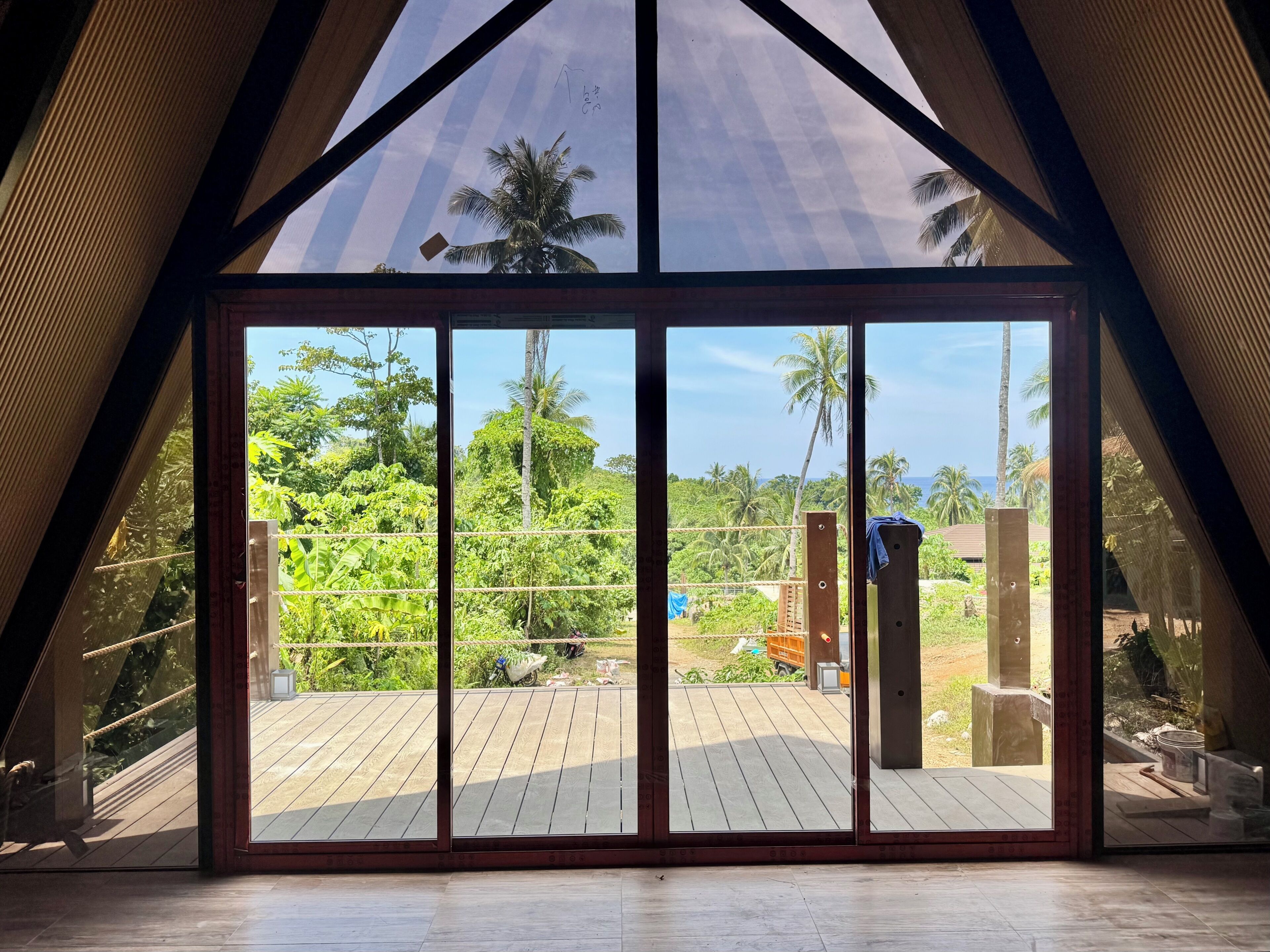Un intérieur moderne avec une grande porte vitrée donnant sur une terrasse extérieure.