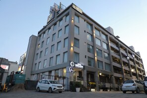 Un hotel de varios pisos con un letrero destacado del Hotel Helios, que presenta un diseño arquitectónico moderno con techo plano y ventanas grandes.