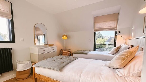Ein Schlafzimmer mit einem großen Bett, einem Schminktisch, einem Sessel und einer Lampe.