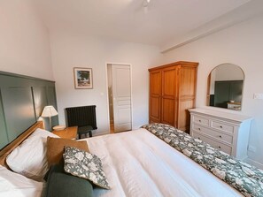A bedroom with two beds, a dresser, a mirror, and a radiator. - Ker Paravel · Family villa · Beach 4 min · Garden (Saint-Lunaire)