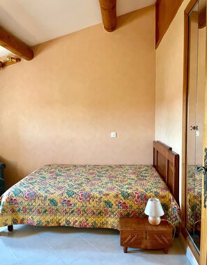 A bedroom with a bed, a nightstand, and a wardrobe. - A House Nestled Among Olive Trees • Luberon • Village a 5-minute walk away (Saint-Saturnin-lès-Apt)
