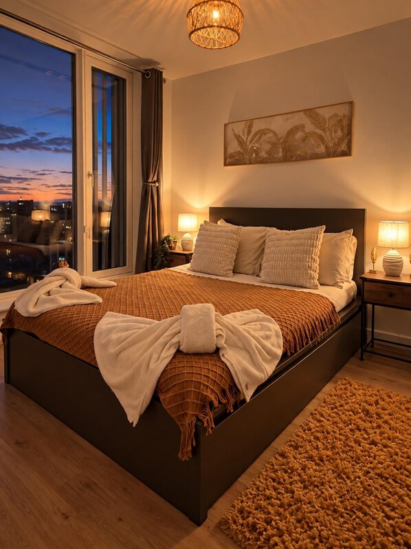 Un dormitorio moderno con una cama grande, vistas a la ciudad y un elemento decorativo en la pared.