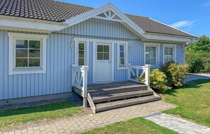A single-story house with a front porch, a door, and a small set of steps leading to the entrance. - 2 bedroom cozy home in Bogø By (Bogø By)