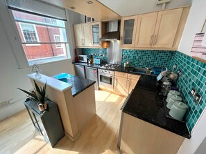 A kitchen with wooden cabinets, a gas stove, a microwave, and a sink.