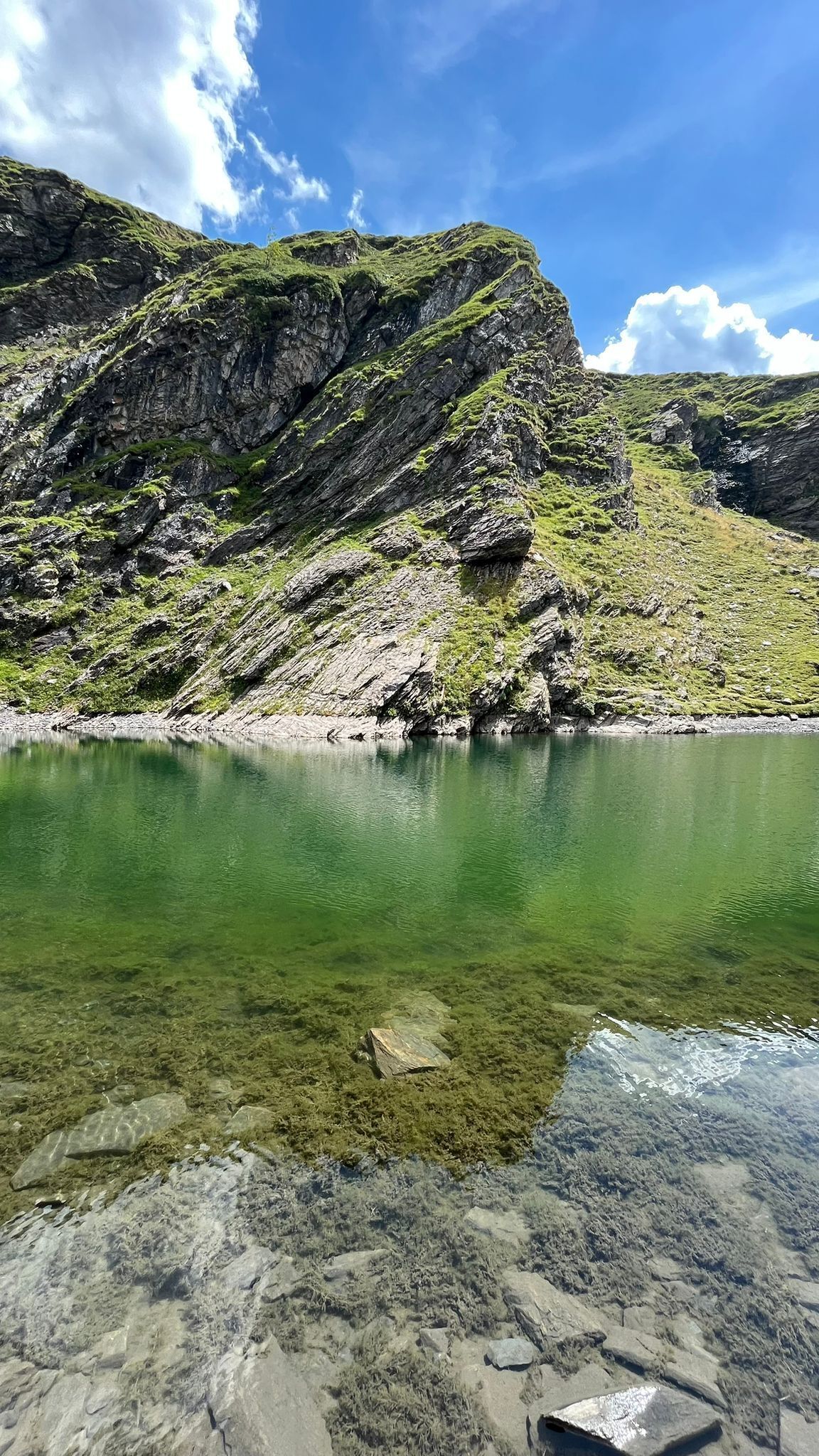 A clear lake surrounded by rocky terrain.