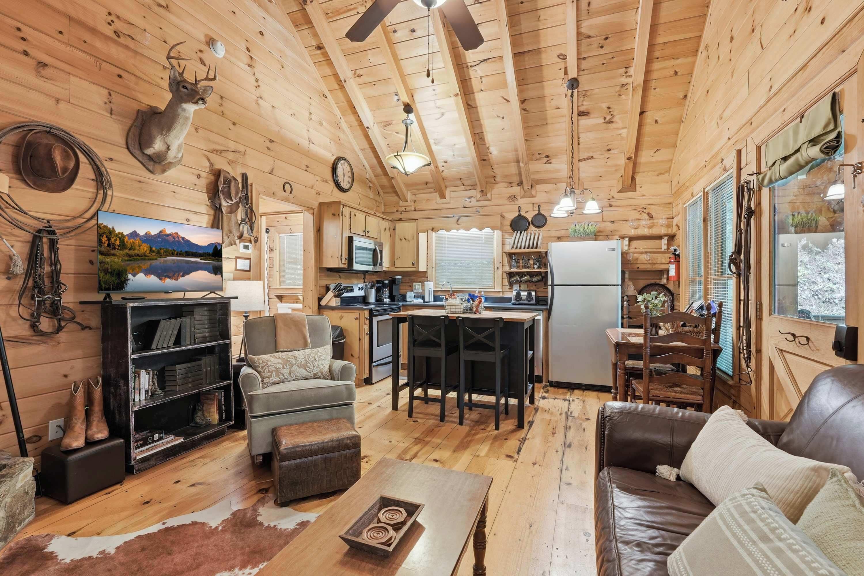 A cabin interior with a kitchen, dining area, and living room.