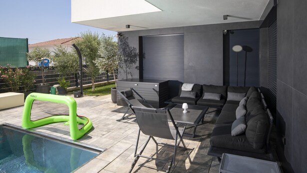 A modern outdoor patio with a pool, seating area, and a covered section. - Apartment Dorota with private Pool near Fažana (Pula)