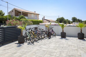 Eine Dachterrasse mit mehreren parkenden Fahrrädern und Topfpflanzen.