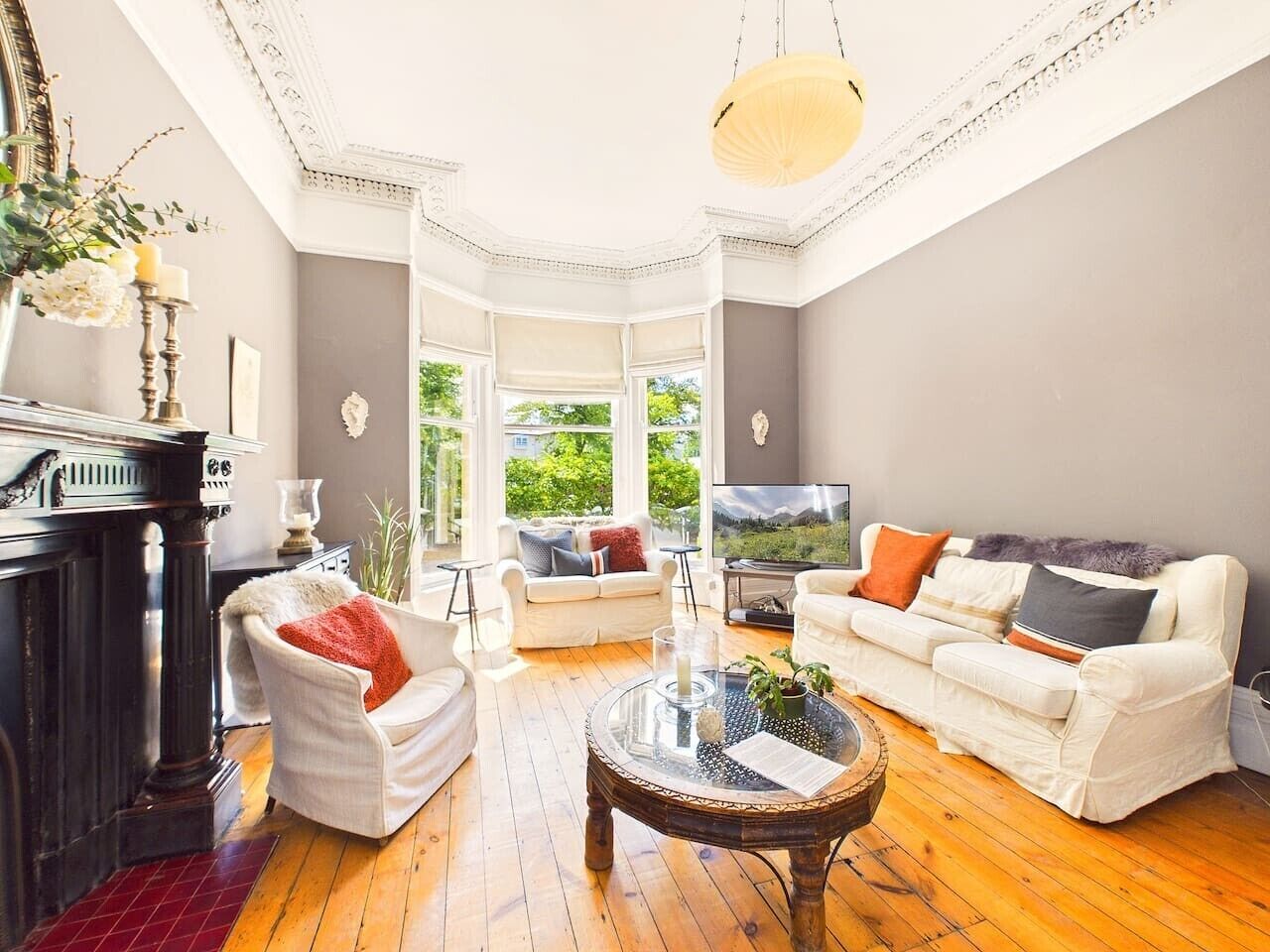 A spacious living room with a fireplace, two sofas, a coffee table, and a television.