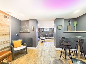 Ein modernes Interieur mit Essbereich, Barhocker und einer Küche im Hintergrund.