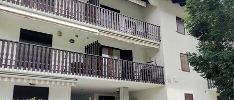 Un immeuble à plusieurs étages doté de balcons, d’une entrée sécurisée et d’un jardin bien entretenu.