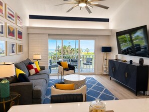 A modern living room with a sofa, chairs, a TV, and a balcony with a view. - Beach Villa 2126: Rare 2-Story Gulf-Front Gem – Panoramic Views & Brand New Loft (Captiva)