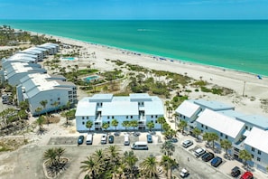 Un hôtel situé en bord de mer, composé de plusieurs bâtiments, doté d’une piscine et d’un parking.
