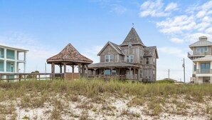 Une maison située sur la côte, dotée d’un belvédère imposant, de nombreuses fenêtres et d’un balcon.
