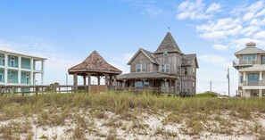 A coastal house with a prominent gazebo, multiple windows, and a balcony. - The Gothic House With Beachfront (Pensacola)