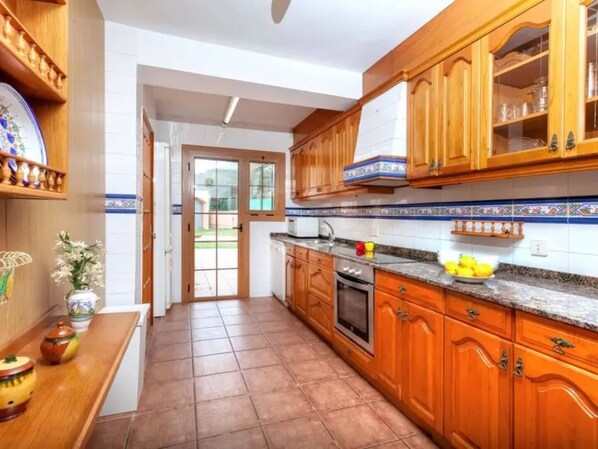 A kitchen with wooden cabinets, a countertop, and a tiled backsplash.