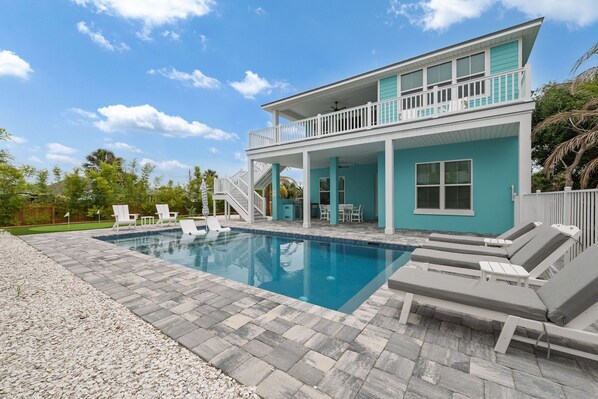 A two-story house with a swimming pool, outdoor seating, and a covered patio area. - Seashell Oasis - Heated Pool/Hot Tub/Putting Green/Walk to Beach (St. Augustine)
