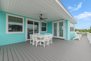 A covered outdoor area with a table and chairs, a ceiling fan, and a view of the sky. - Seashell Oasis - Heated Pool/Hot Tub/Putting Green/Walk to Beach (St. Augustine)
